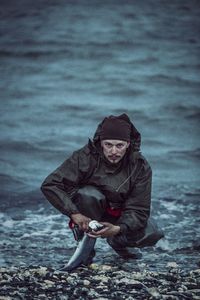 Woman sitting on snow covered sea