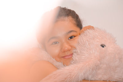 Close-up portrait of smiling girl over white background