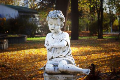 Statue of angel in park during autumn