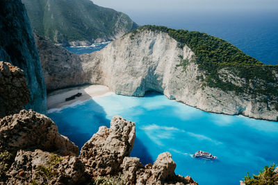 Aerial view of rocks by sea against sky