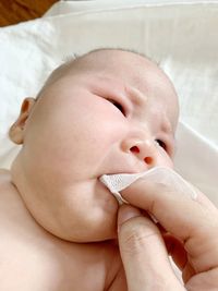 Close-up of baby girl lying on bed