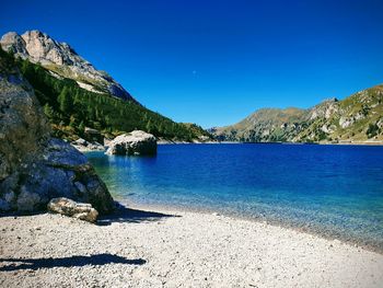 Scenic view of lake against clear blue sky