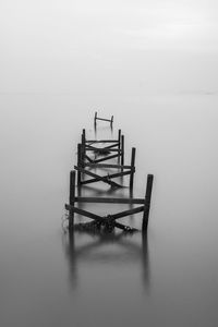 Wooden chairs and table in sea during winter