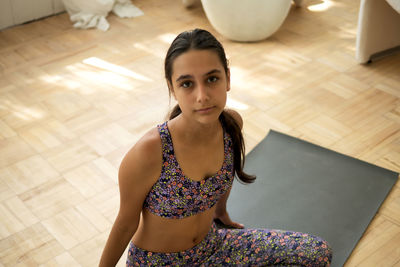 Portrait of young woman sitting on floor