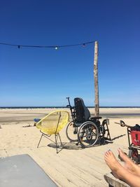 Bicycle on beach against clear blue sky