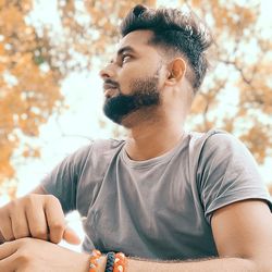 Portrait of young man looking away outdoors