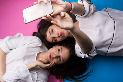 Young woman taking selfie from mobile phone with friend