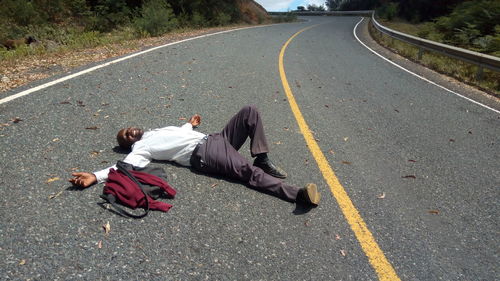 Man lying down on road