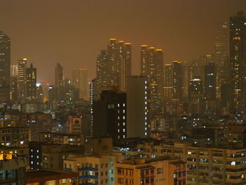 Illuminated cityscape against sky at night