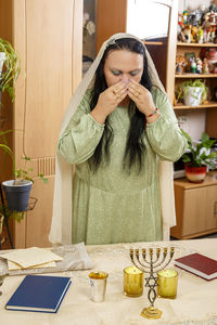 Midsection of woman holding smart phone at home
