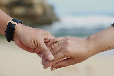 Midsection of couple holding hands