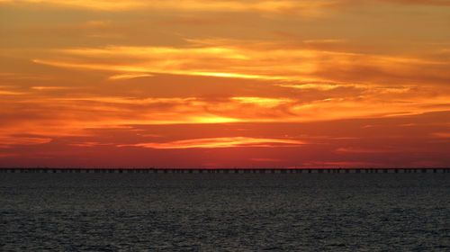 Scenic view of sea against dramatic sky during sunset