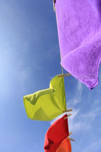 Low angle view of laundry drying on clothesline against sky