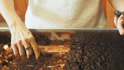 Midsection of woman cutting cake in tray