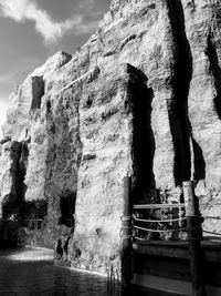 People on rock formation against sky