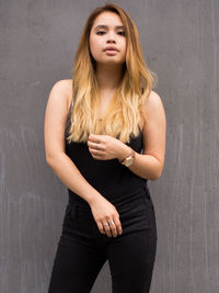 Portrait of woman standing against wall