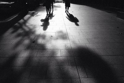 Low section of people walking on tiled floor