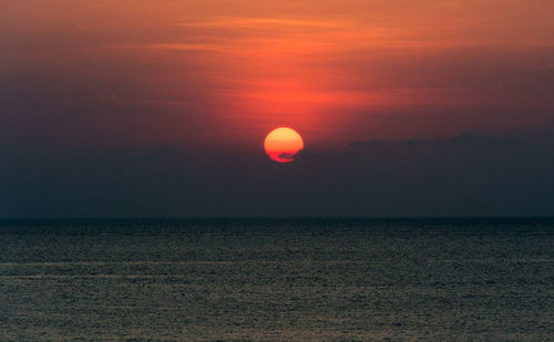 Scenic view of sea against orange sky