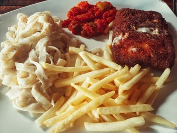 Close-up of pasta with meat and fries in plate