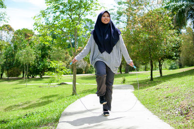 Full length portrait of young woman in park