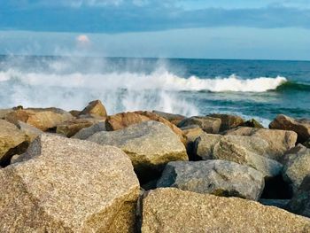 Scenic view of rocks on beach against sky