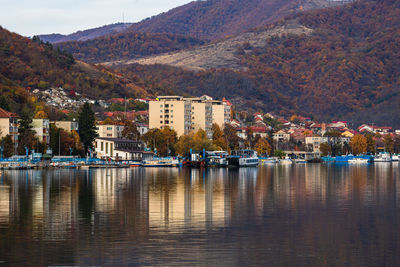 River by buildings in city against sky