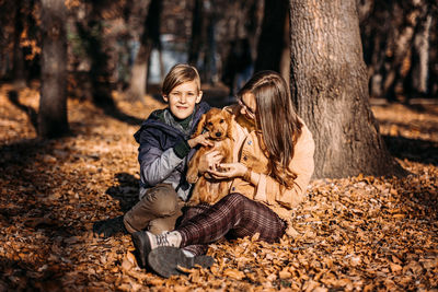 Autumn walks with dog. happy family mother and teen boy son having fun with cute cocker spaniel