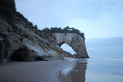 Rock formation in sea against sky