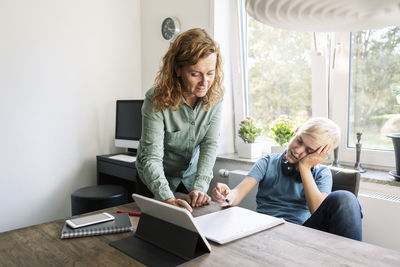 Mother helping son study at home