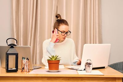 Caucasian brunette young woman working from her home office