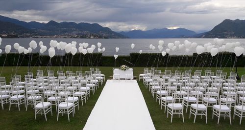 Empty chairs against cloudy sky