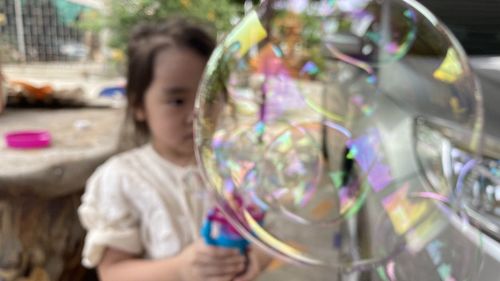 Full length of woman holding bubbles