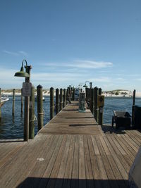 Wooden jetty leading to calm blue sea