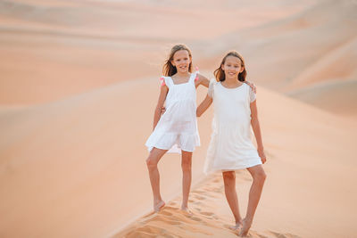 Rear view of women standing on sand