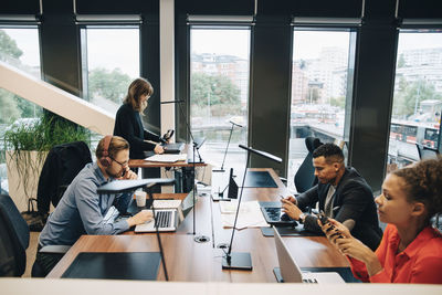 Side view of multi-ethnic business colleagues working at desk in office