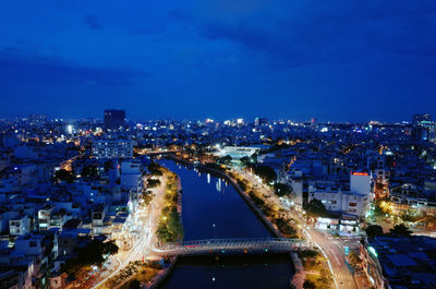 Illuminated cityscape against blue sky