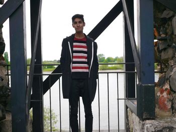 Portrait of young man standing against lake