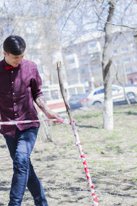 Tattooed man wrapping cordon tape on stick