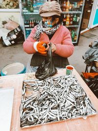 Woman holding fish for sale at market