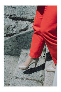 Low section of woman standing on sidewalk