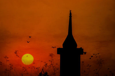 Silhouette of bell tower against orange sky