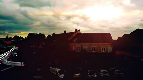 View of city against cloudy sky at sunset
