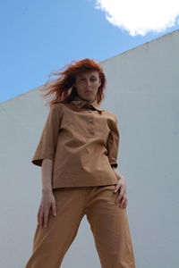 Low angle view of woman standing against clear sky