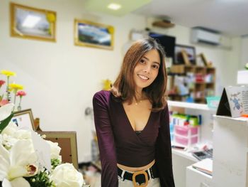 Portrait of smiling young woman standing in store