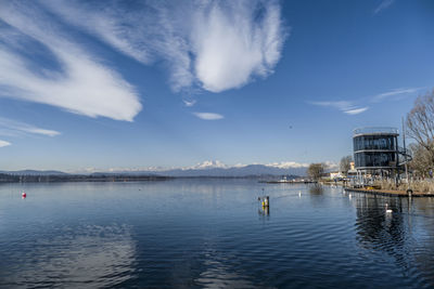 Scenic view of lake by buildings against sky