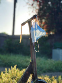 Close-up of umbrella hanging on wood in field