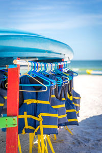 Deck chairs on beach against blue sky