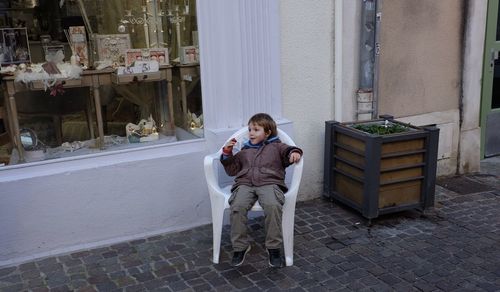 Full length of man sitting on seat