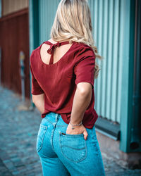 Rear view of woman standing against wall