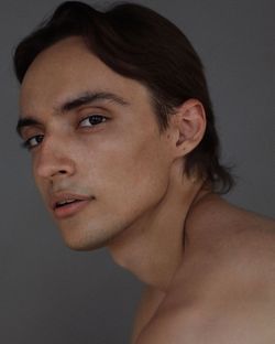 Close-up portrait of shirtless young man